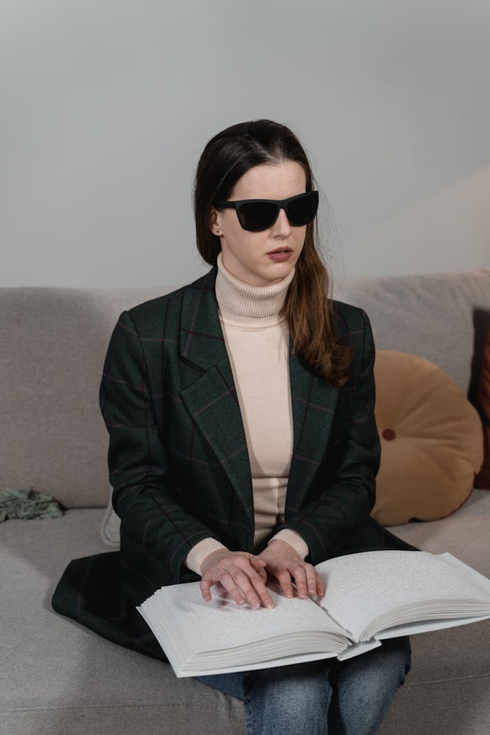 Woman in Black Coat and Black Sunglasses Reading a Book using Braille System