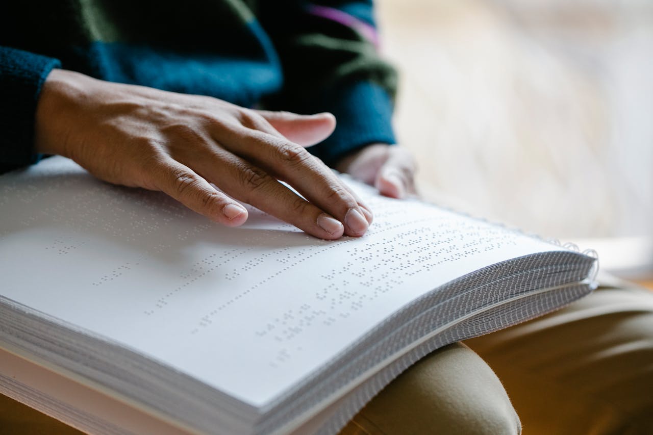 Close-Up Photo Of Person Using Braille